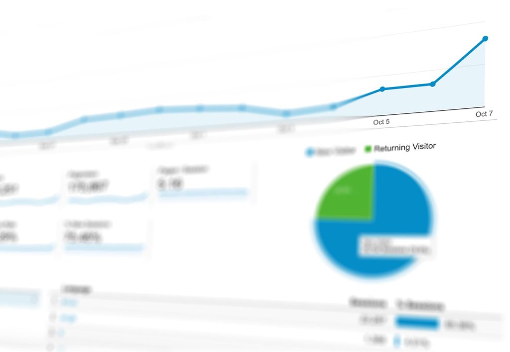 Persona de negocios analizando métricas de conversión web en una laptop, con gráficos y datos que muestran el éxito de la transformación de visitantes en clientes.
