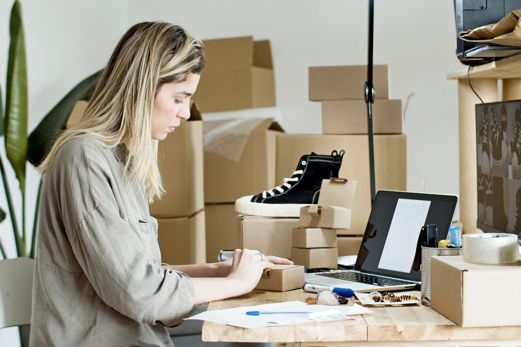 Mujer empresaria de pyme en Costa Rica sonriendo mientras gestiona su tienda online desde una laptop, con un diseño ecommerce moderno y funcional.